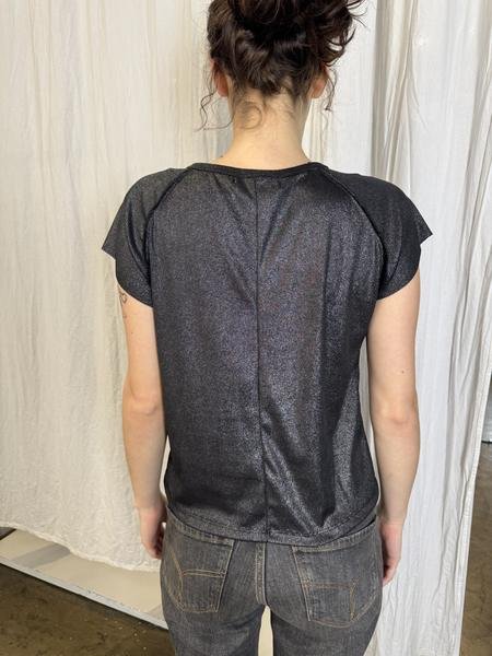 Foto del cliente: la remera de espalda, en modelo de calce, frente a una cortina