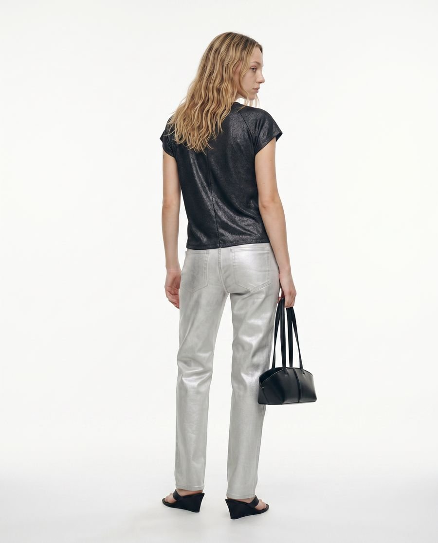 Plano general de espalda, con cartera negra y sandalias