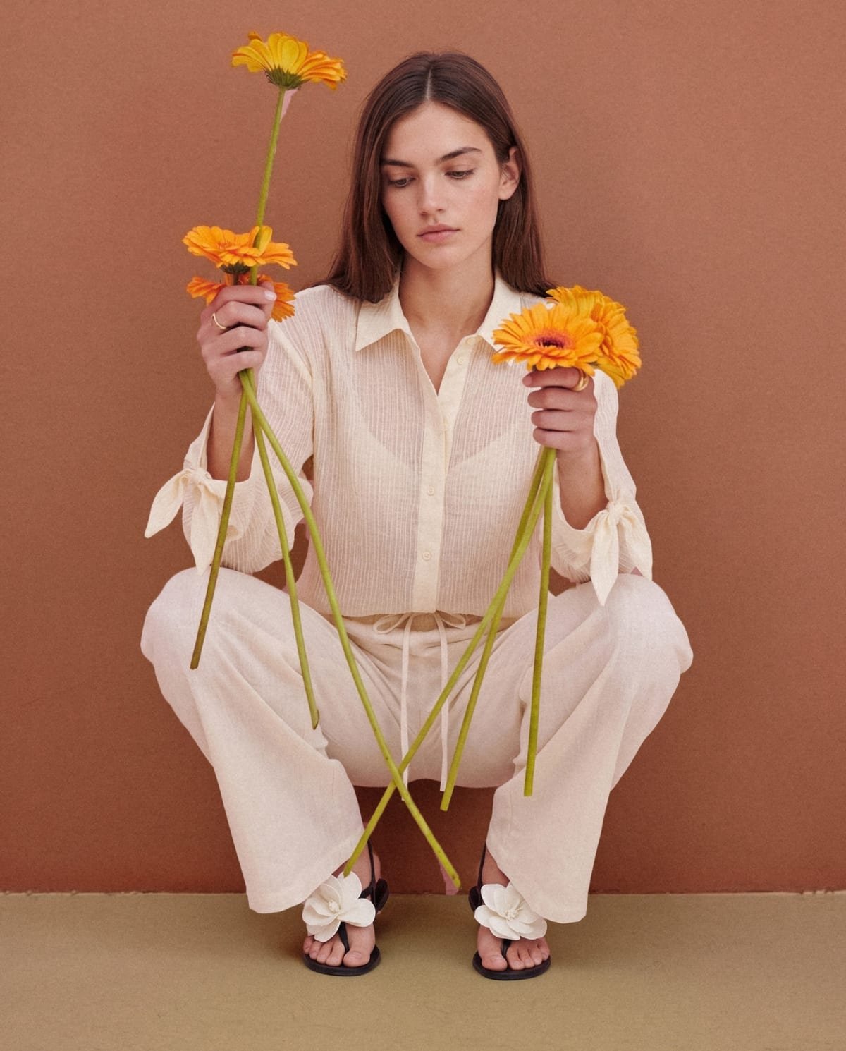 Koxis: conjunto crudo sobre fondo terracota, con flores naranjas